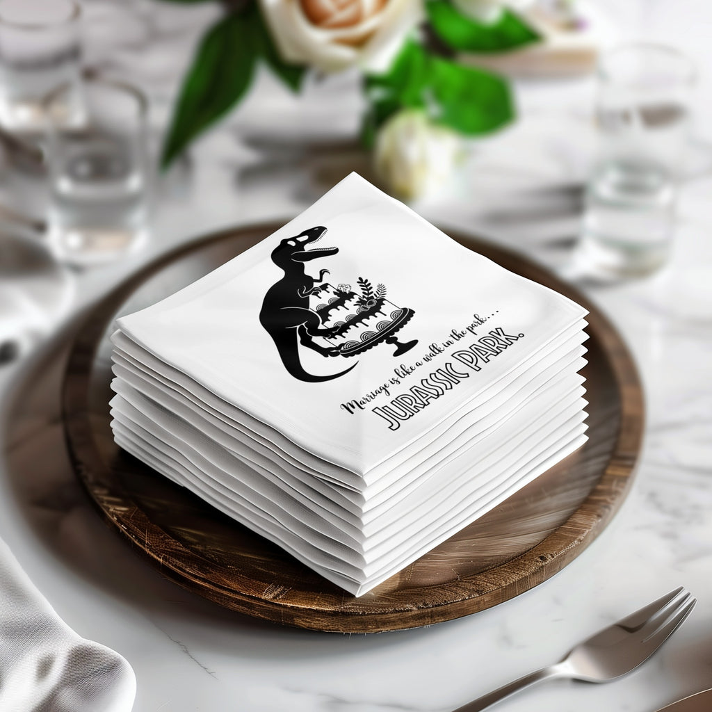 Stack of white napkins with Jurassic Park logo and dinosaur cake graphic.