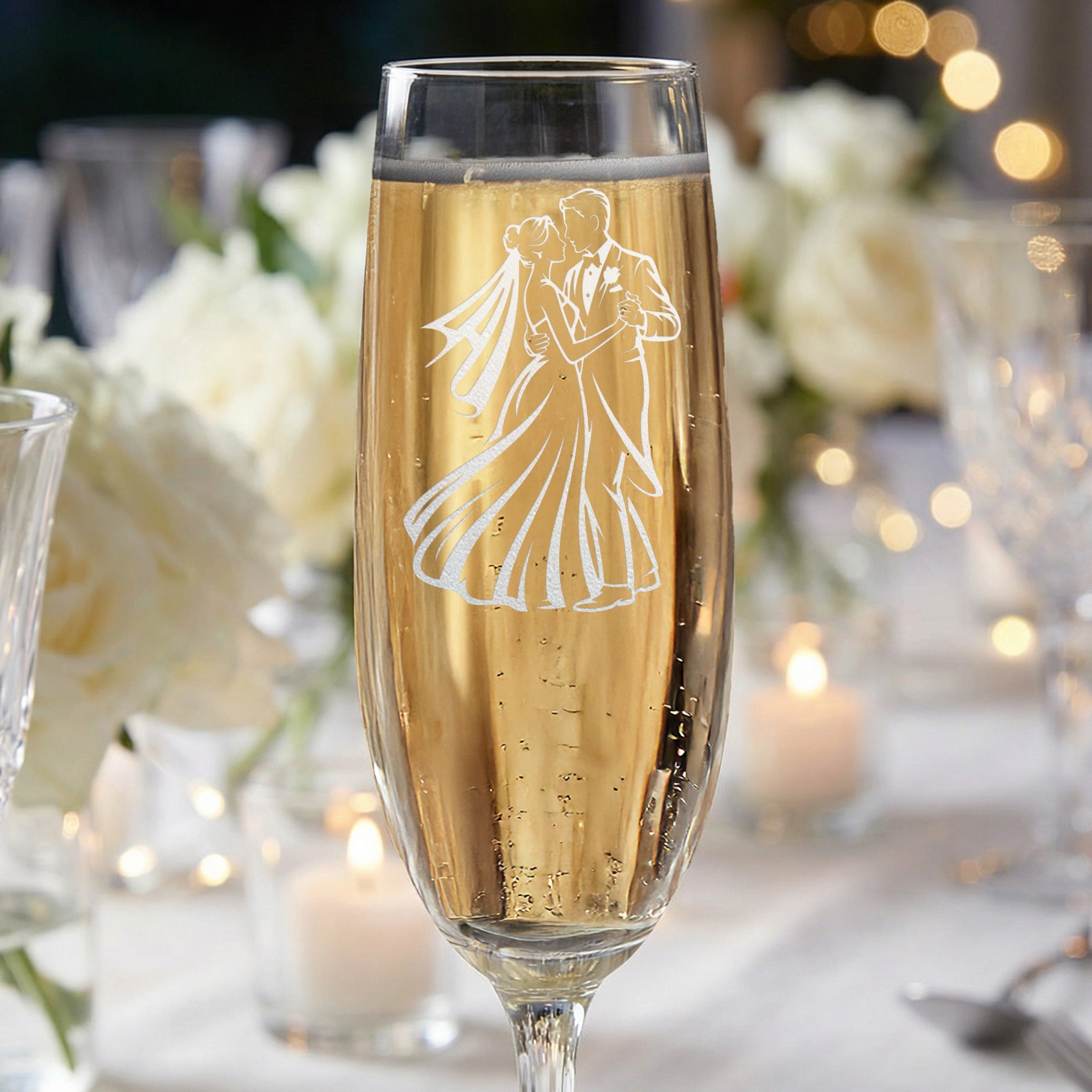 Champagne flute with engraved silhouette of a dancing couple, at a wedding.