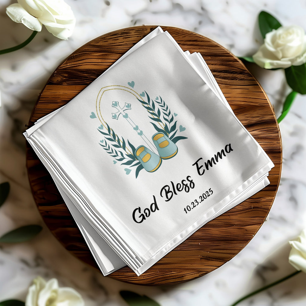 White handkerchief with cross, baby shoes, and "God Bless Emma 10.23.2025".
