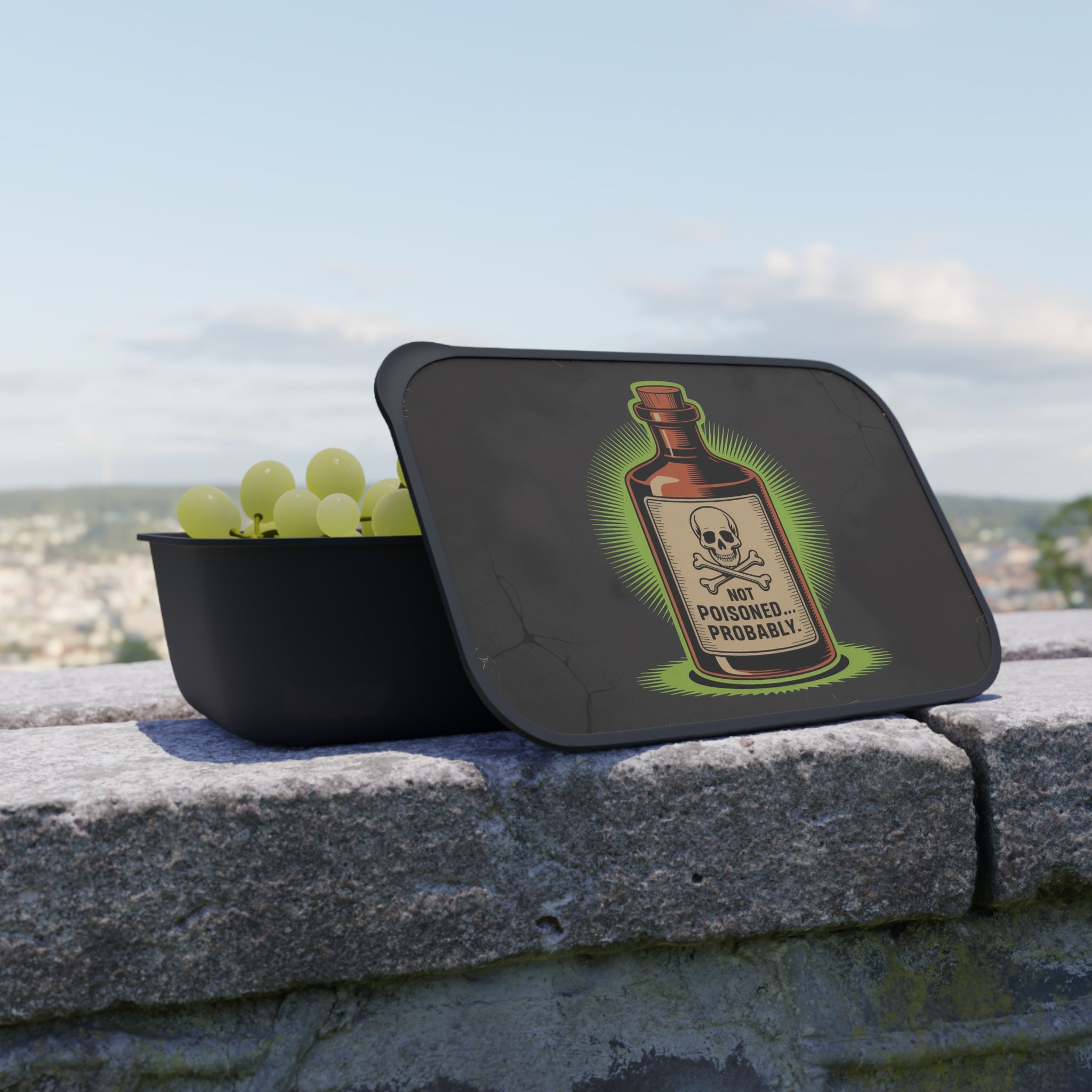Black lunchbox with grapes and a "Not Poisoned. Probably." skull and bottle sticker.