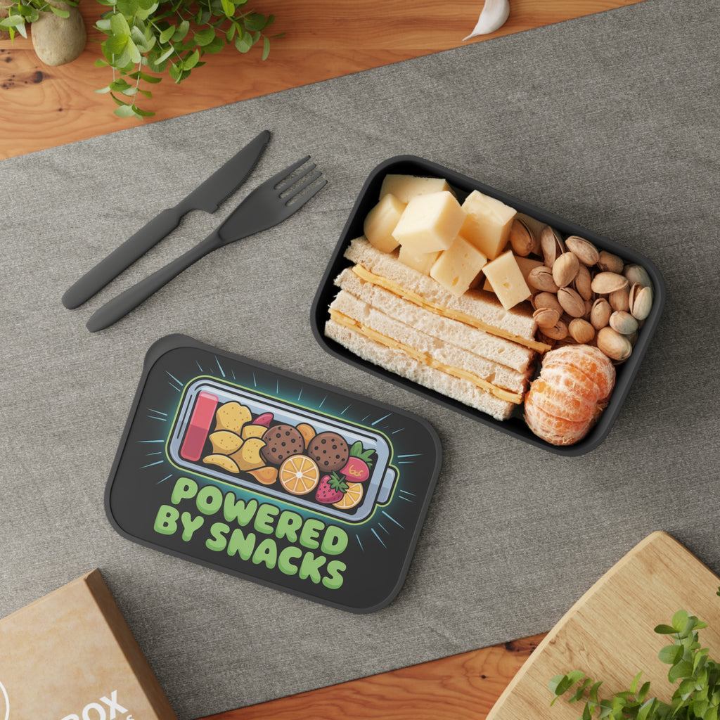 Lunchbox with "Powered by Snacks" and food illustrations next to a filled lunchbox.