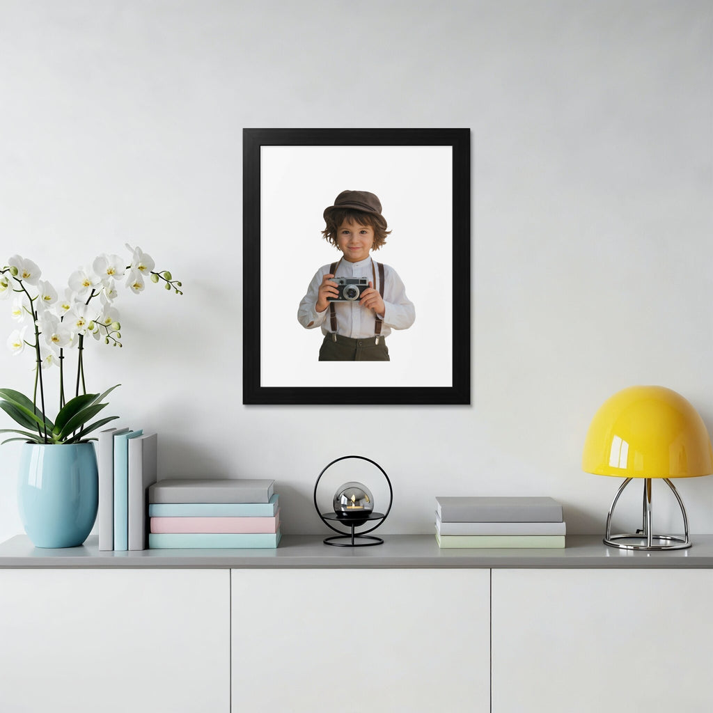 Boy in hat and suspenders holds vintage camera in framed picture.