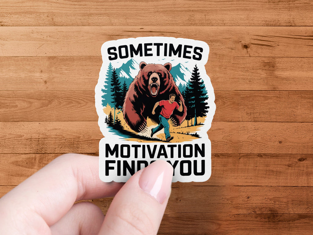 Sticker of a man running from a bear with text "SOMETIMES MOTIVATION FINDS YOU".