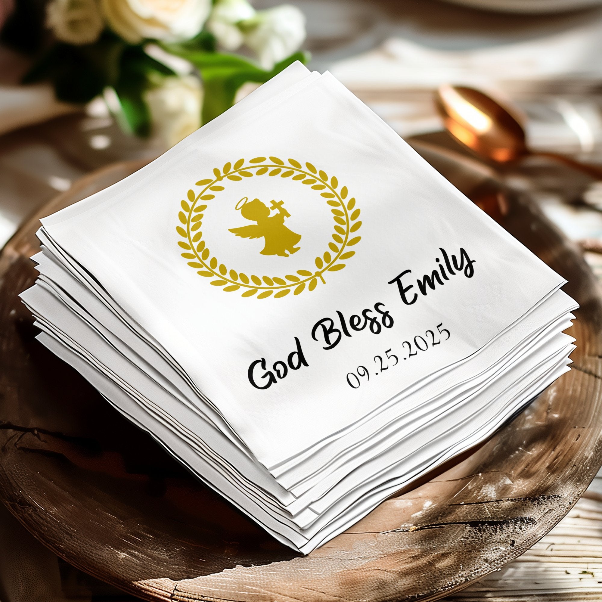 Stack of white napkins with gold angel, wreath, and custom text.