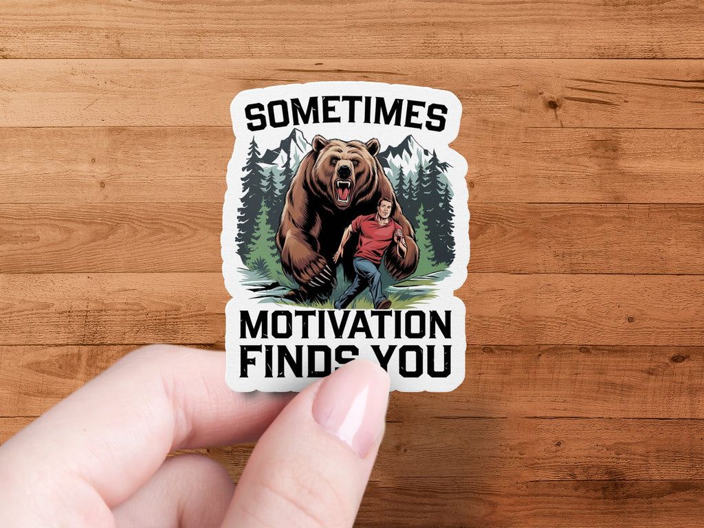 Sticker of a man running from a bear with text "SOMETIMES MOTIVATION FINDS YOU".