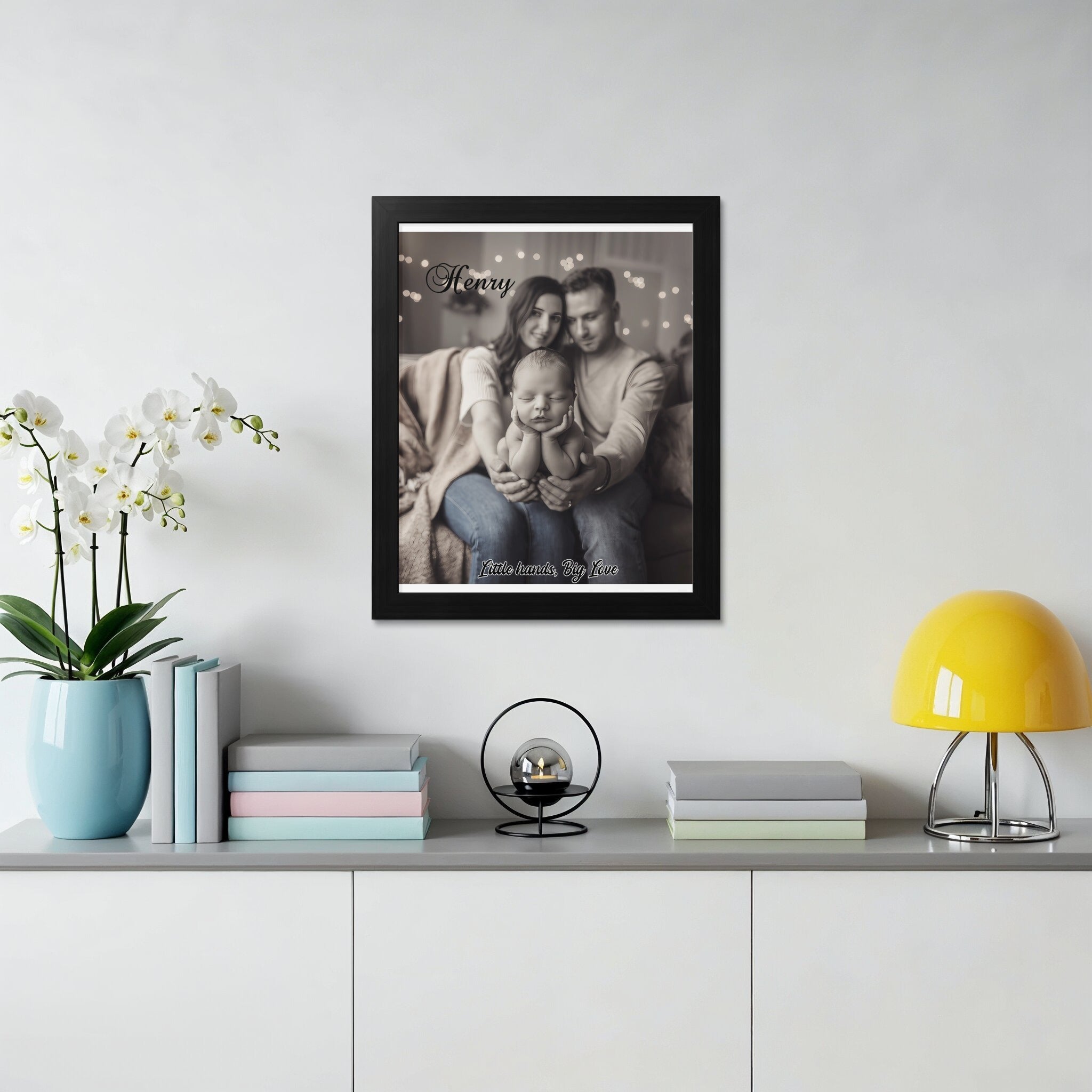 Black framed photo of parents holding baby with text "Henry, little hands, big love".