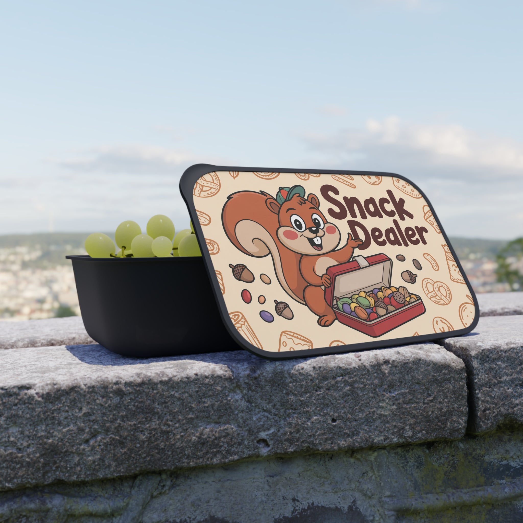 Black snack container with lid open showing grapes and "Snack Dealer" illustration.