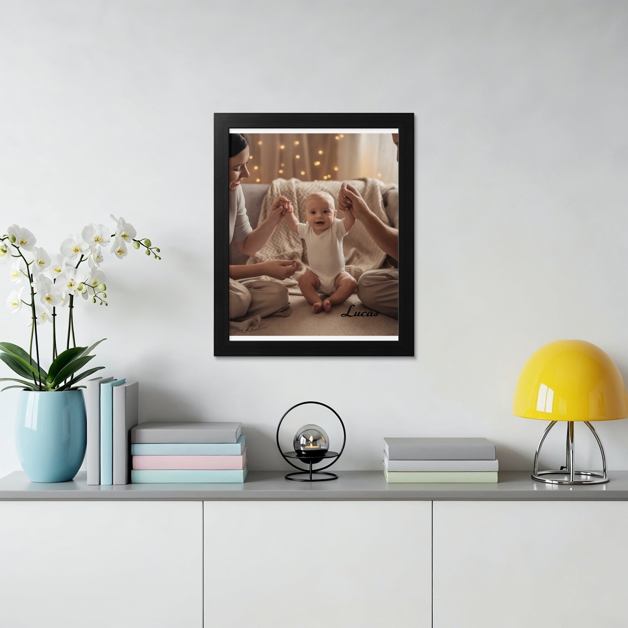 Framed photo of a baby reaching for parents' hands, "Lucas" text.