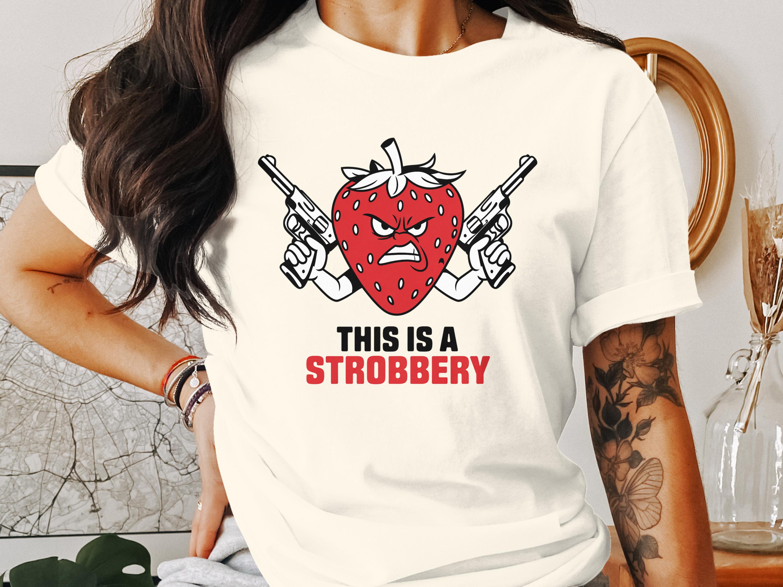 Illustration of an angry strawberry with guns, text reads "THIS IS A STROBBERY".