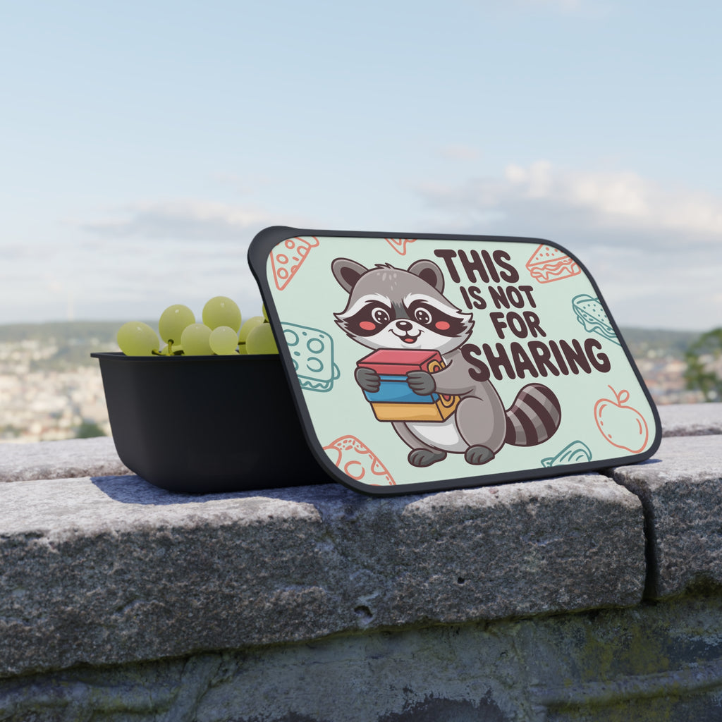 Raccoon character holding books on lunchbox lid with text "THIS IS NOT FOR SHARING."