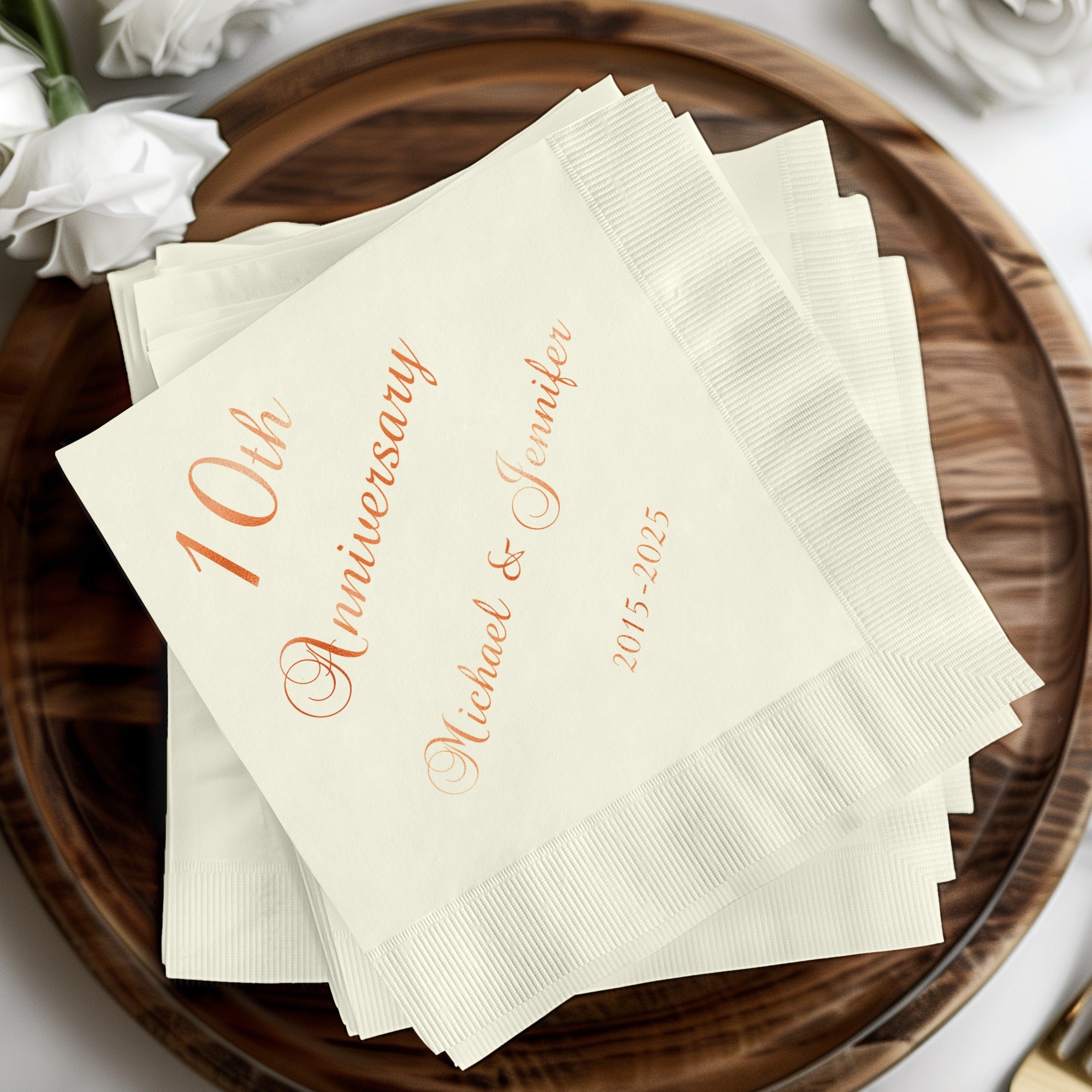 Cream-colored napkins with "10th Anniversary Michael & Jennifer 2015-2025" in copper text.