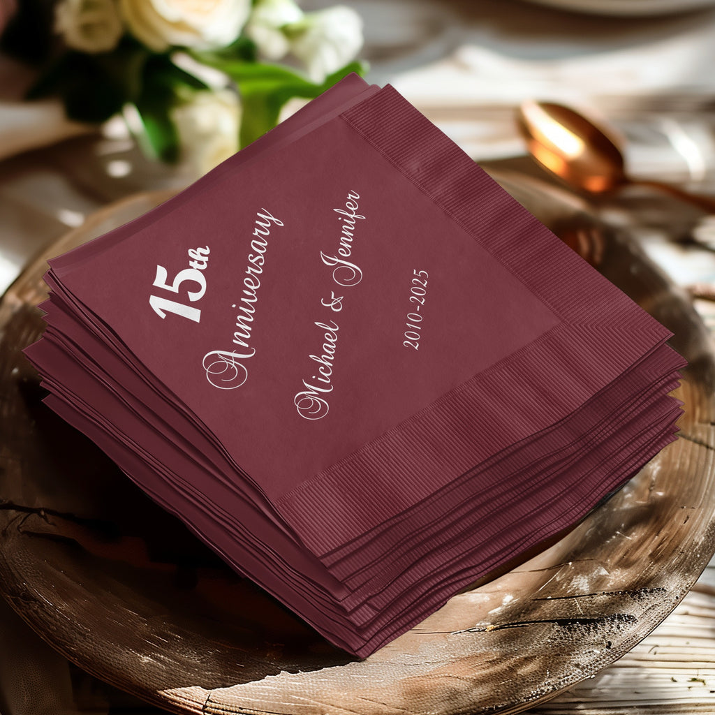 Burgundy napkins stacked, reading "15th Anniversary Michael & Jennifer 2010-2025".
