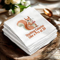 White napkins with a squirrel holding a cupcake and the text "Stashing Calories Like a Pro at 30".