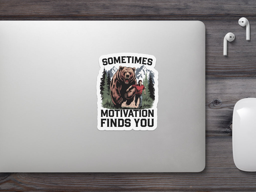 Bear and man with text "SOMETIMES MOTIVATION FINDS YOU" on laptop.
