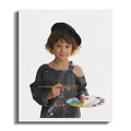 Young artist in overalls and beret holds brush and palette with colorful paints.