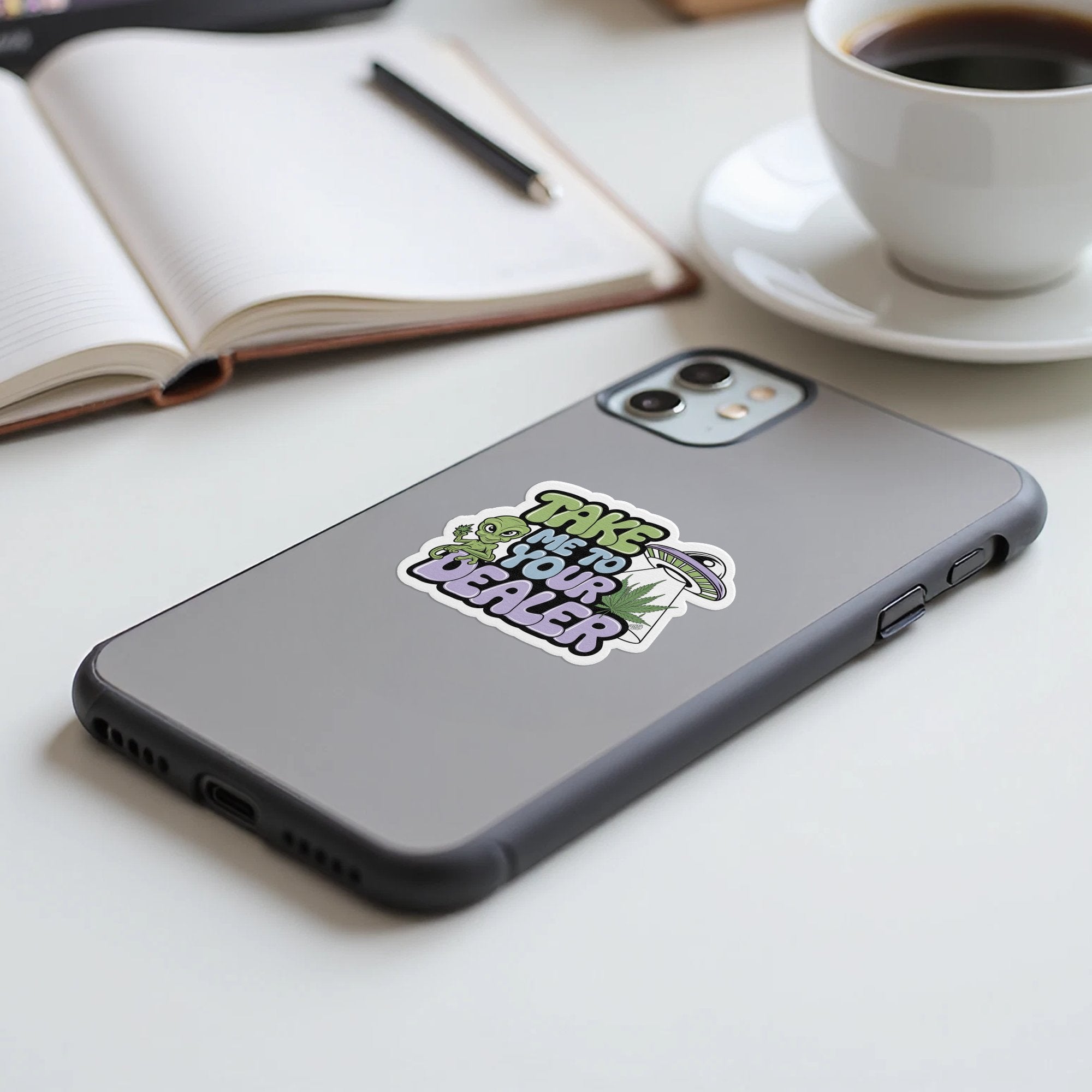 Sticker with "Take me to your dealer" text and alien on phone.