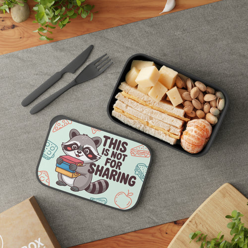Lunchbox with raccoon illustration and sandwich, cheese, and nuts inside.