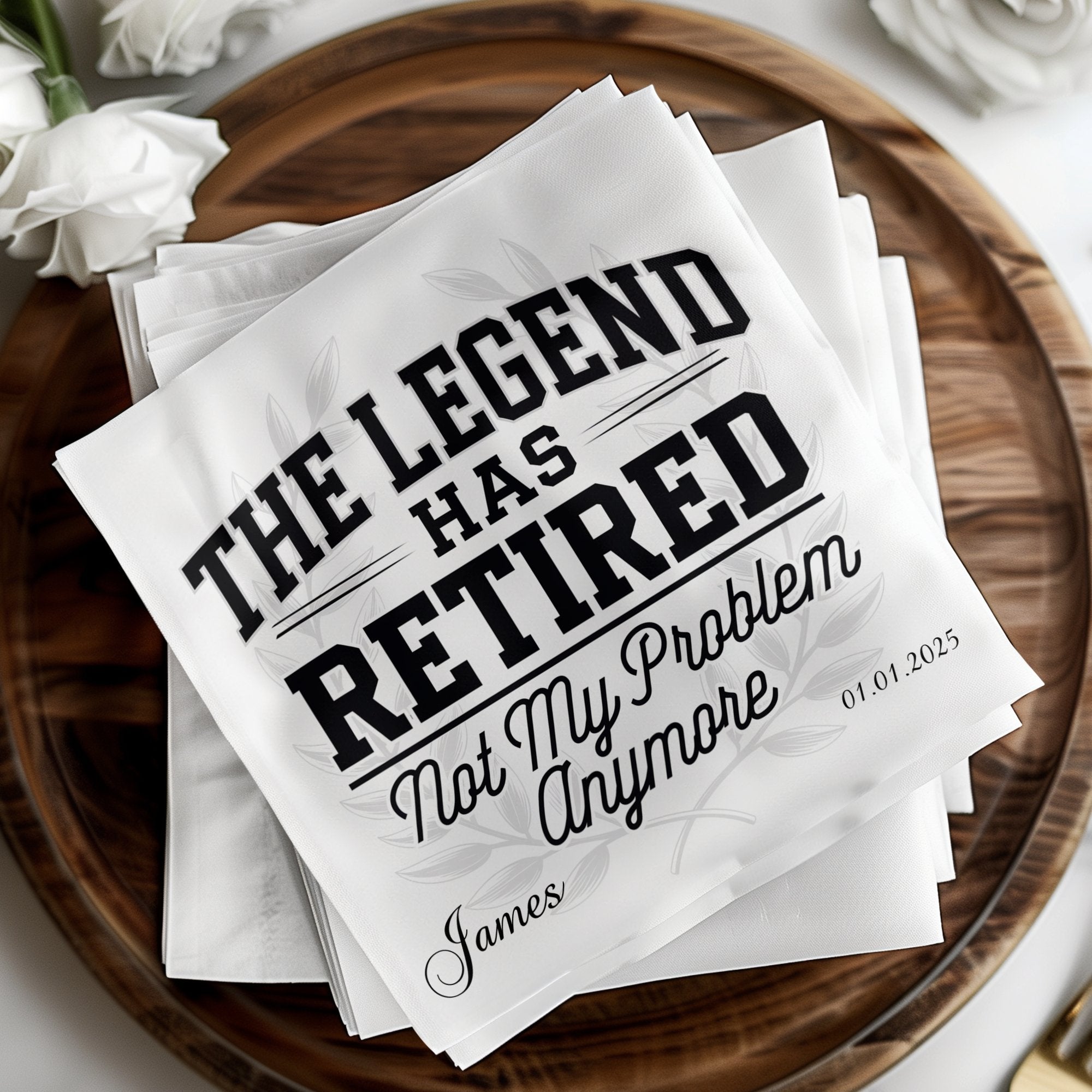 White cocktail napkins with "The Legend Has Retired" and a name and date.