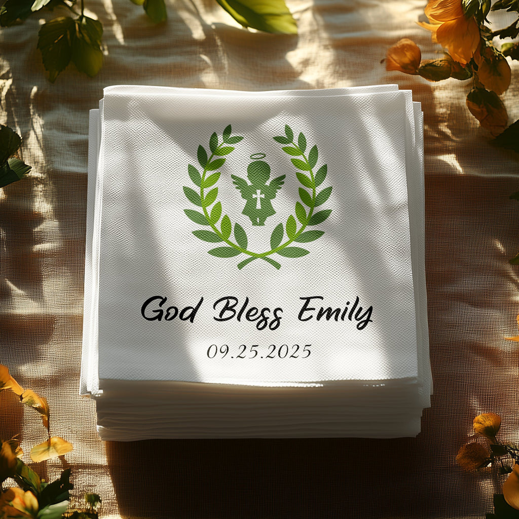 Stack of white napkins with "God Bless Emily" and date, framed by greenery.
