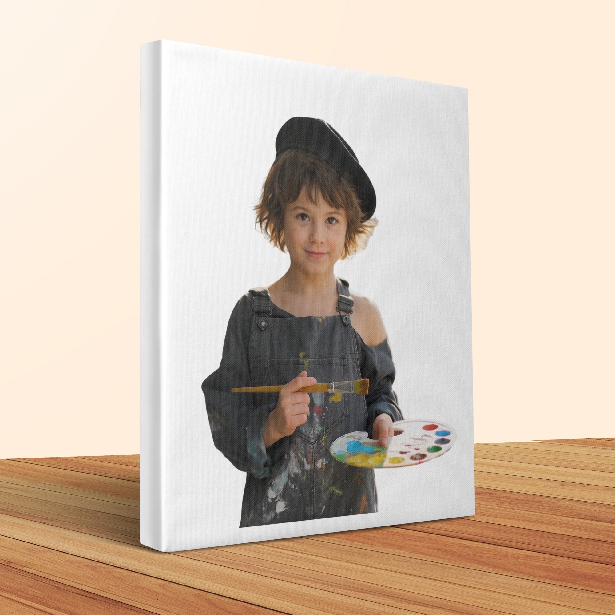 Child in overalls and beret holding a palette and paintbrush.