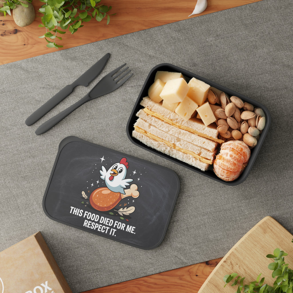 Lunchbox with chicken graphic and text, containing a sandwich, cheese, and nuts.