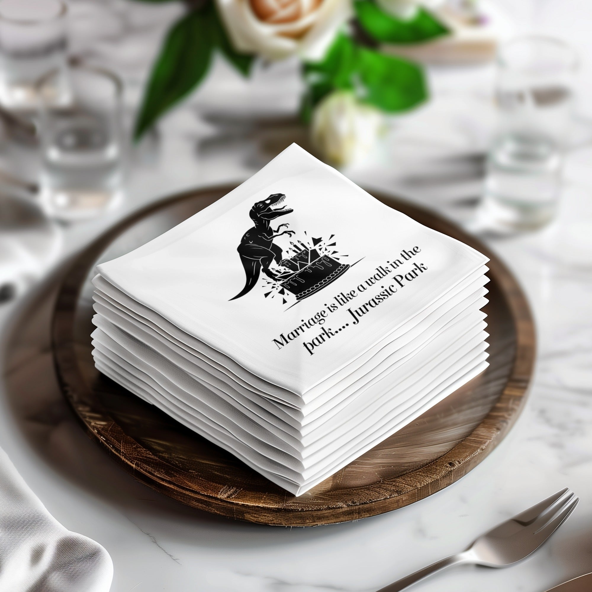 Napkins stacked on a wooden charger with Jurassic Park dinosaur and text.