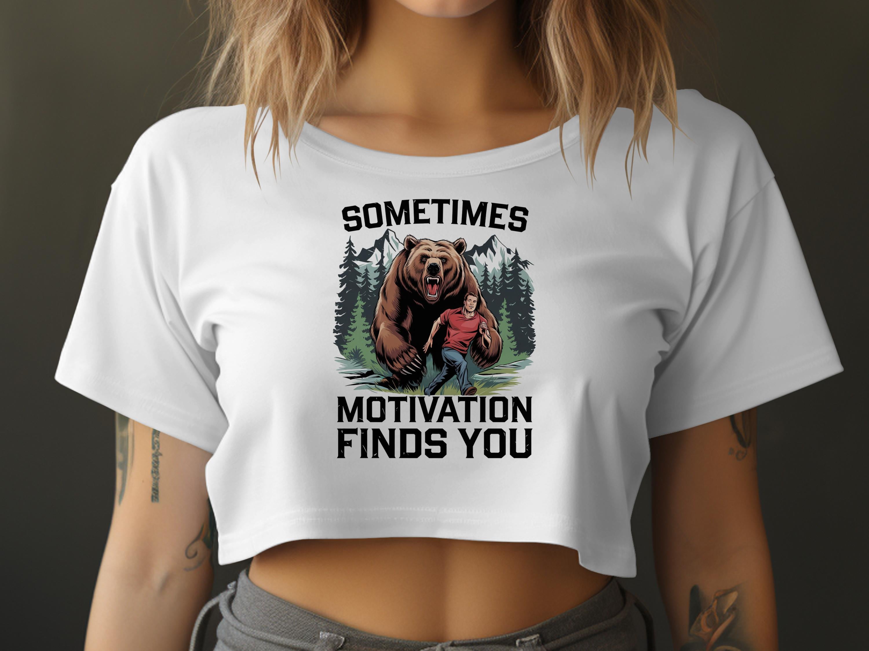 Woman in white crop top with graphic: "Sometimes Motivation Finds You" and a bear.