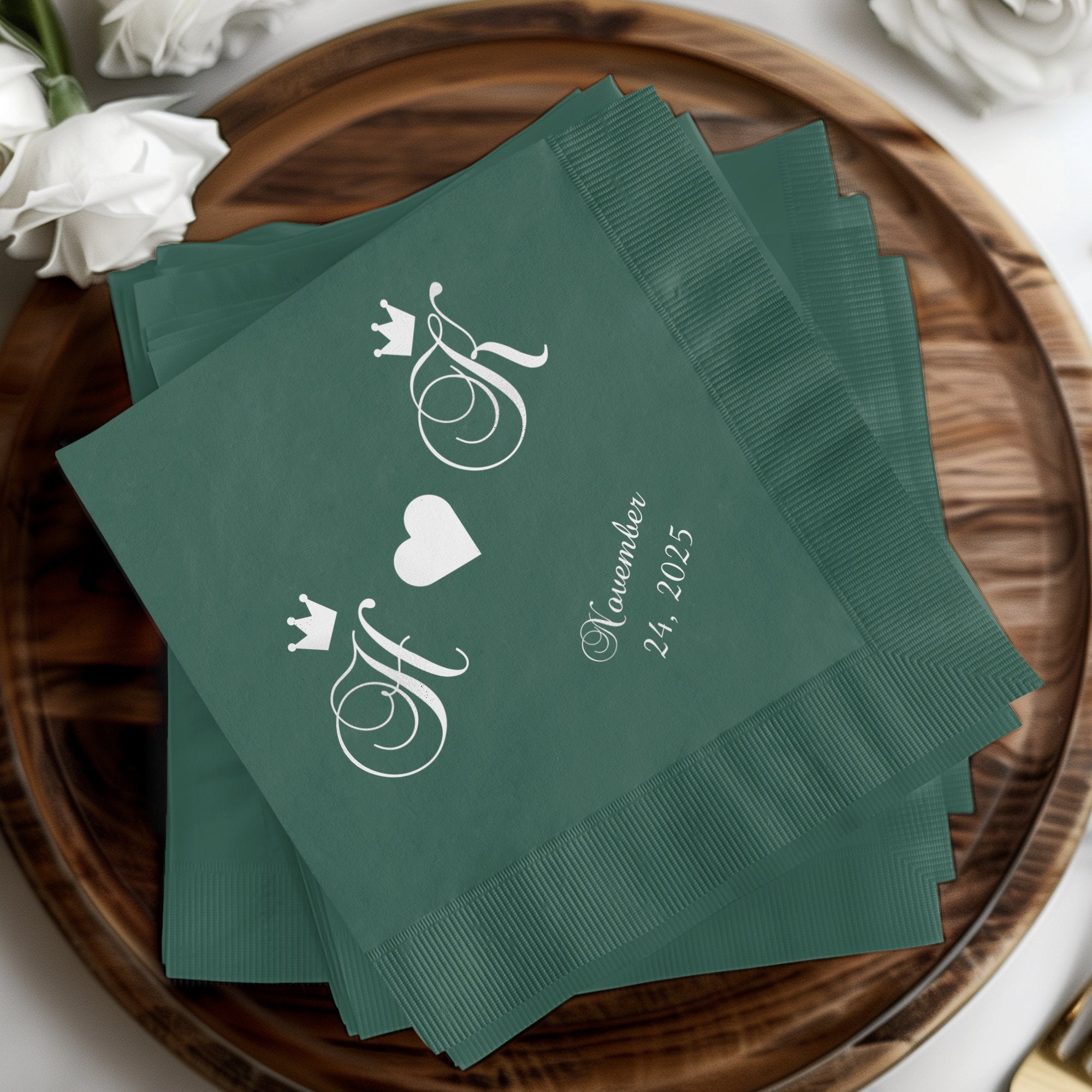 Green cocktail napkins with intertwined initials and a wedding date.