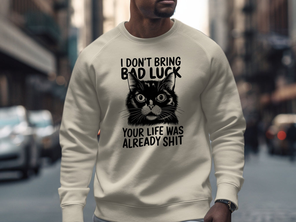 Cream sweatshirt with a black cat illustration and humorous text.