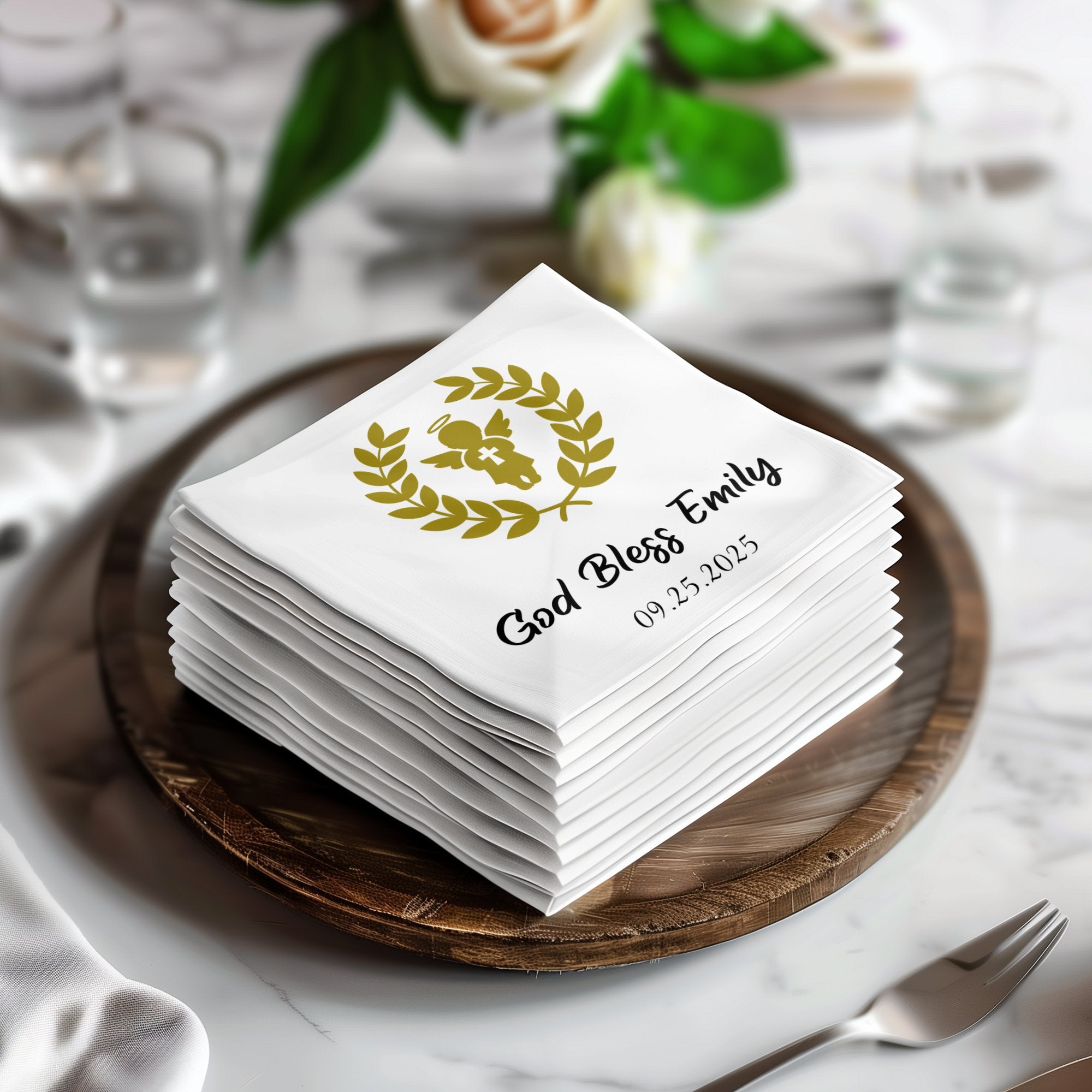 Stack of white cocktail napkins with "God Bless Emily 09.25.2025" and an angel design.