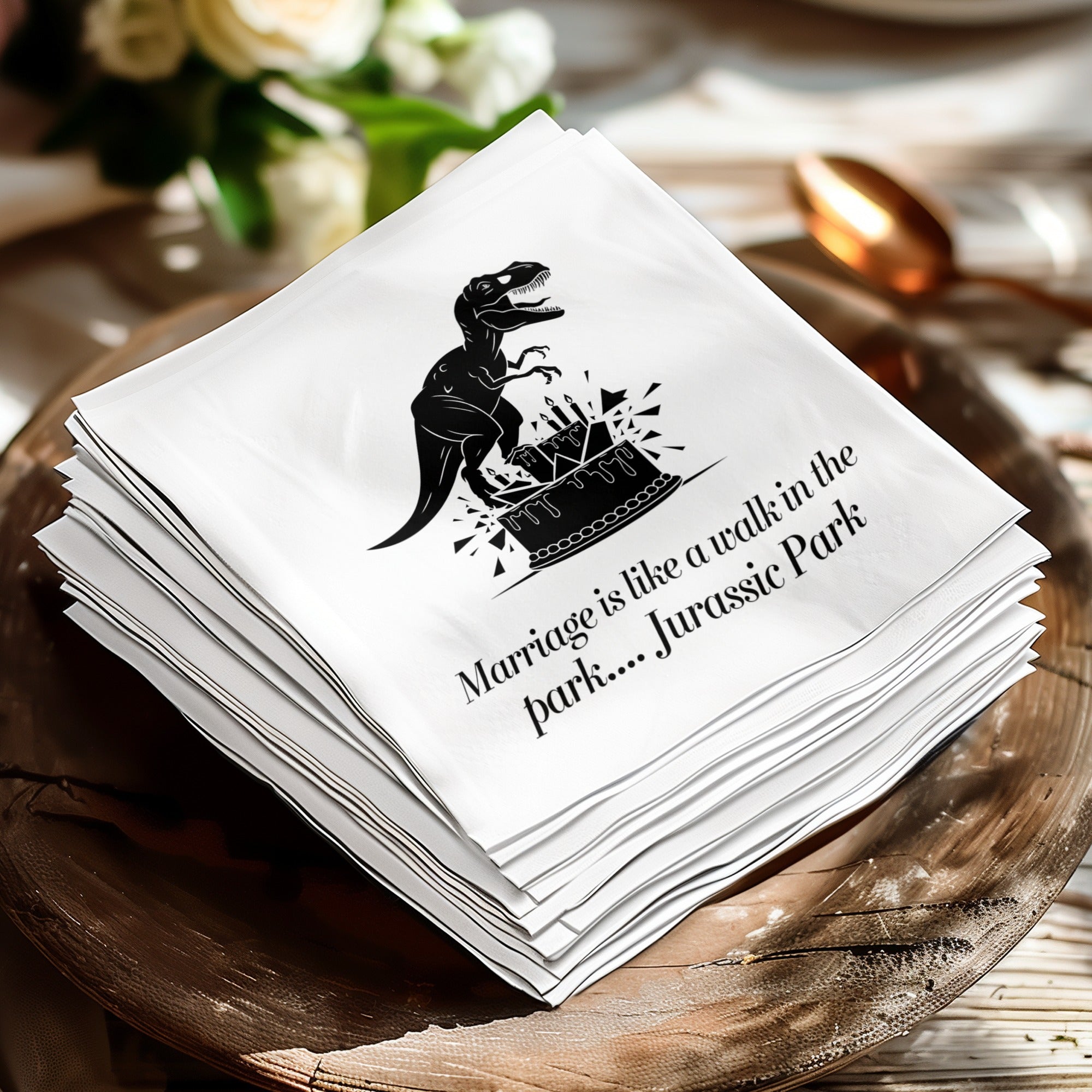 Napkin with a T-Rex on a cake, reading "Marriage is like a walk in the park.... Jurassic Park."