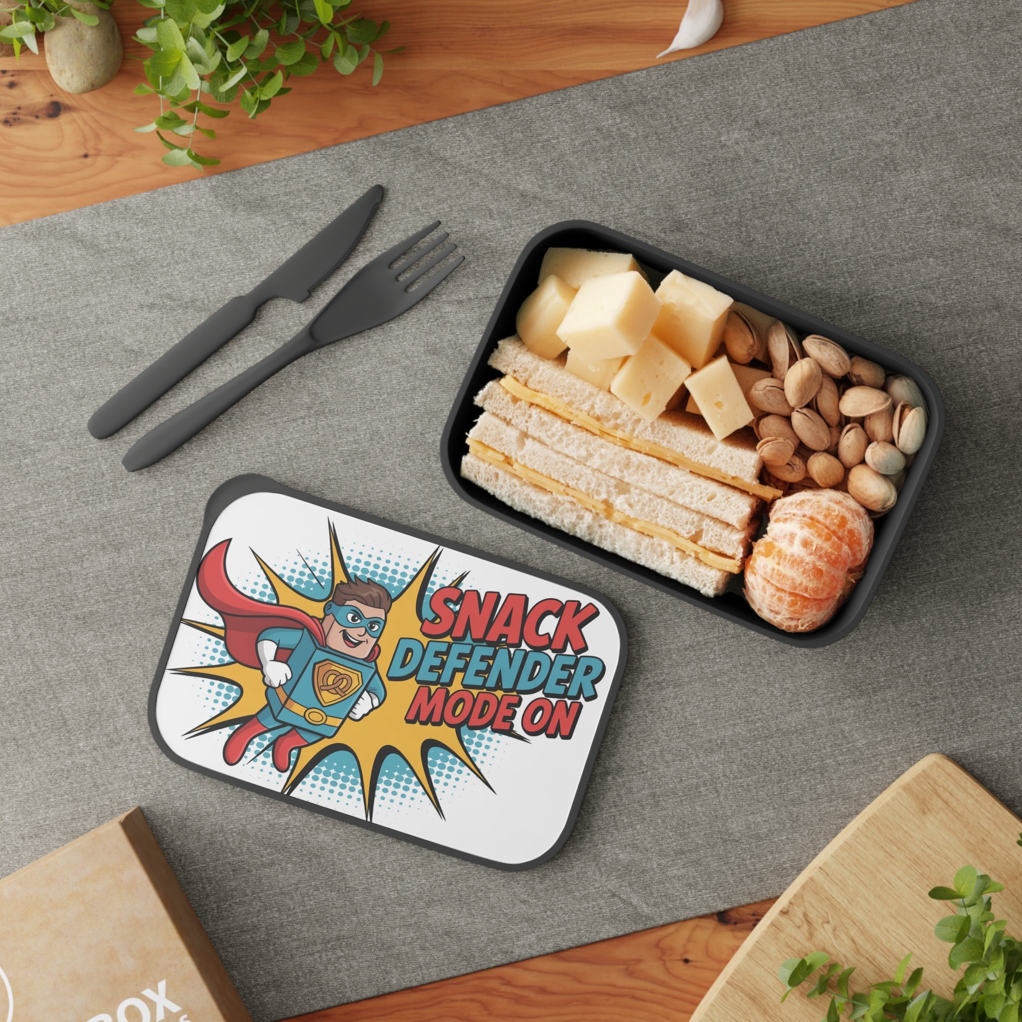 Lunchbox with superhero graphic and sandwiches, cheese, pistachios, and tangerines.