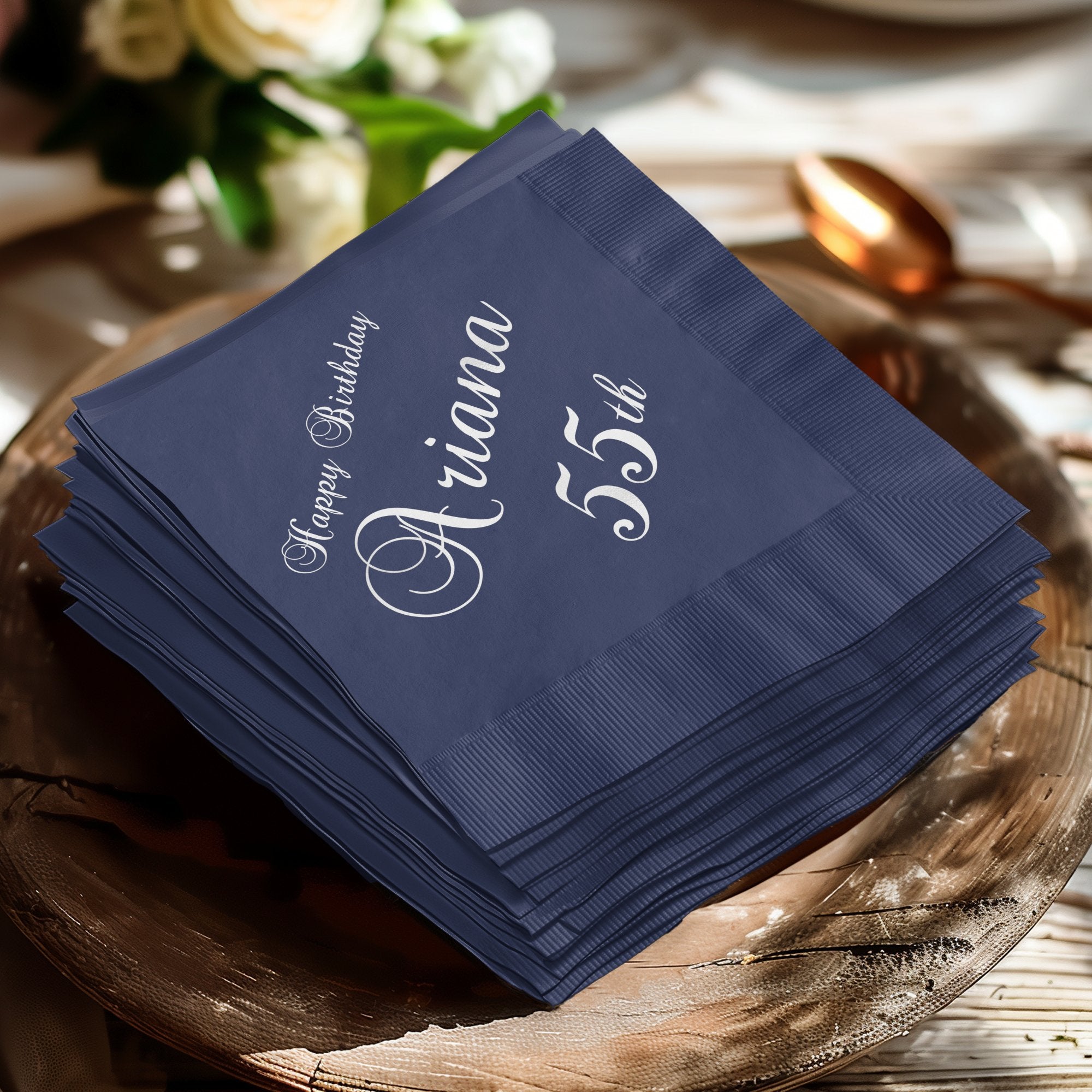 Navy blue cocktail napkins with "Happy Birthday Ariana 55th" text.