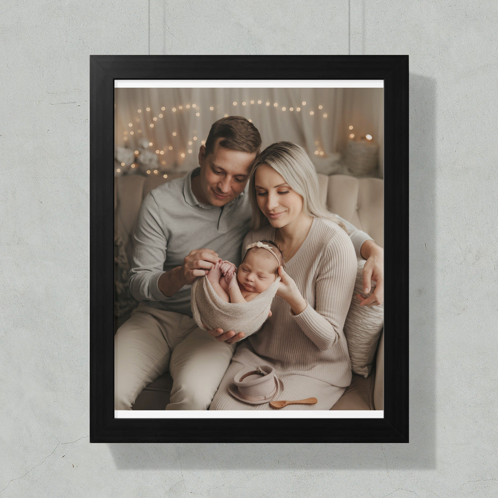 Family holding a newborn baby in a wrap, with bokeh lights in the background.