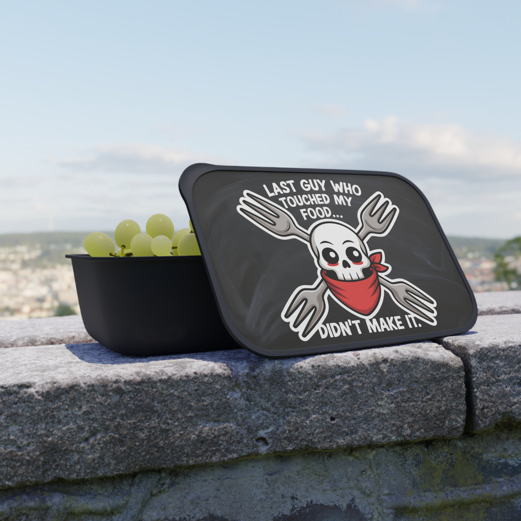 Black bowl with grapes and a lid featuring a skull with crossed forks and text.