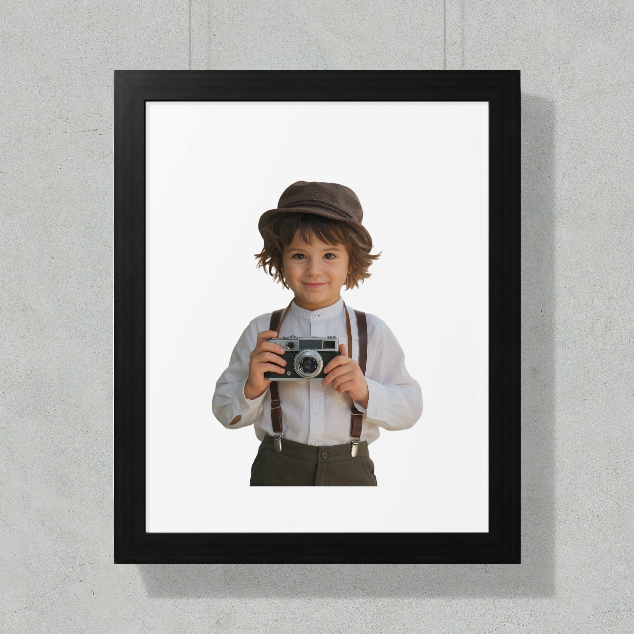 Young boy in hat and suspenders holding vintage camera against white background.