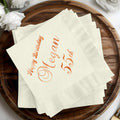 Cream napkins with "Happy Birthday Megan 55th" in rose gold.