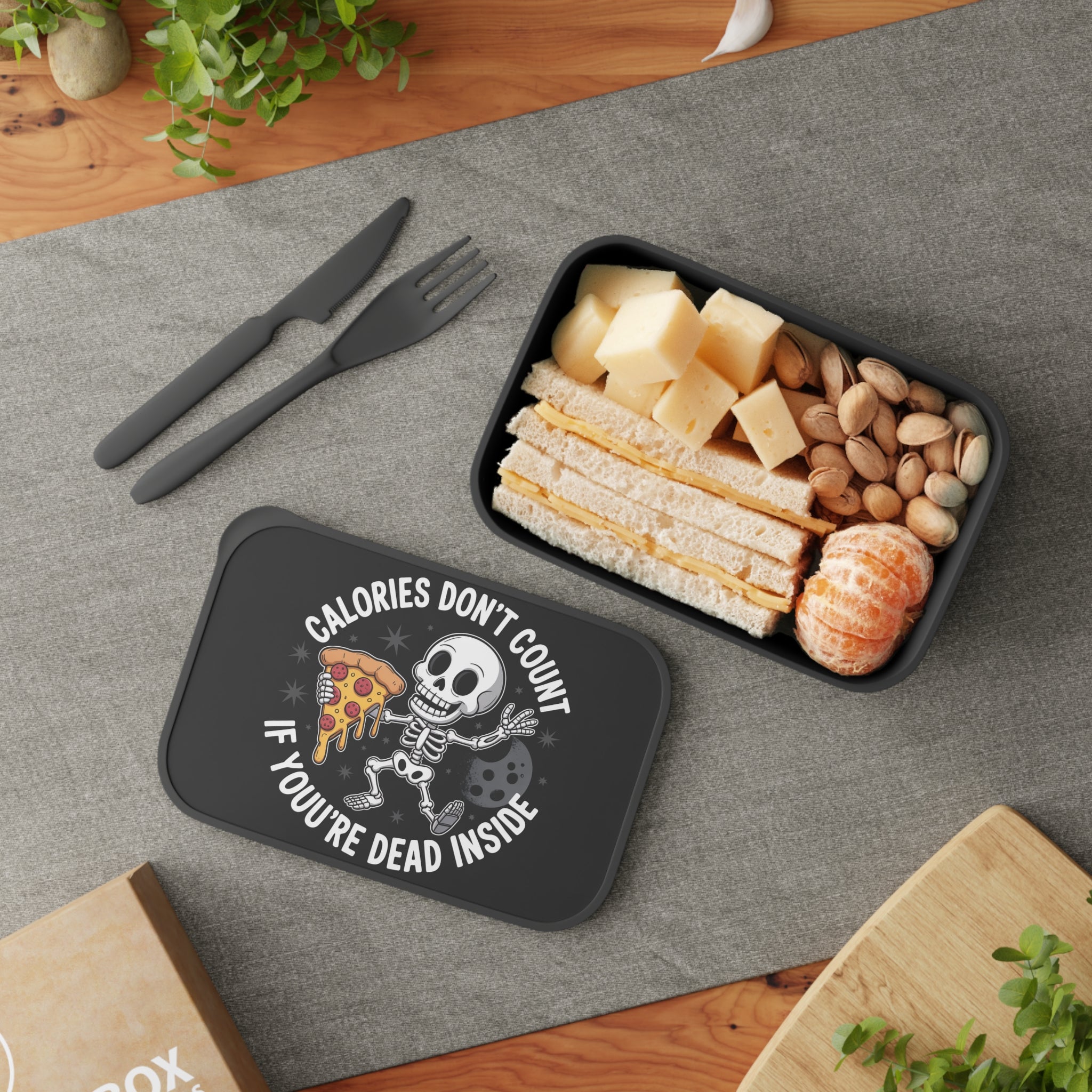 Lunchbox with text "Calories Don't Count If You're Dead Inside" and a skeleton eating pizza.