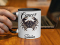 White mug with black rim featuring a Cancer crab and "Sebastian".