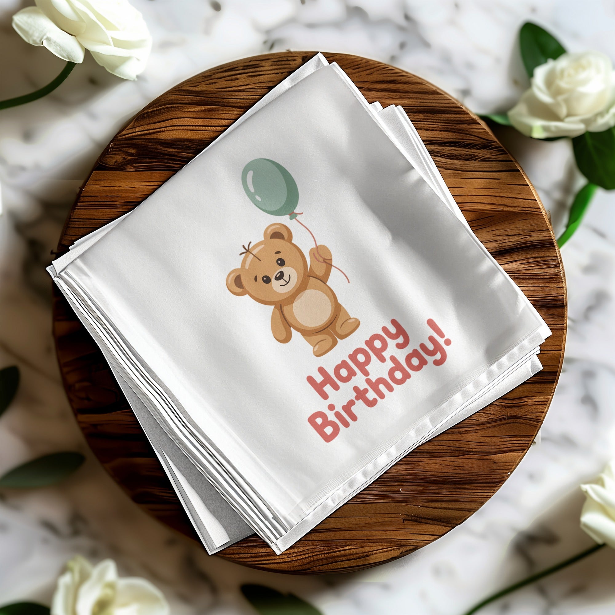 White napkin with teddy bear holding balloon and "Happy Birthday!" text.