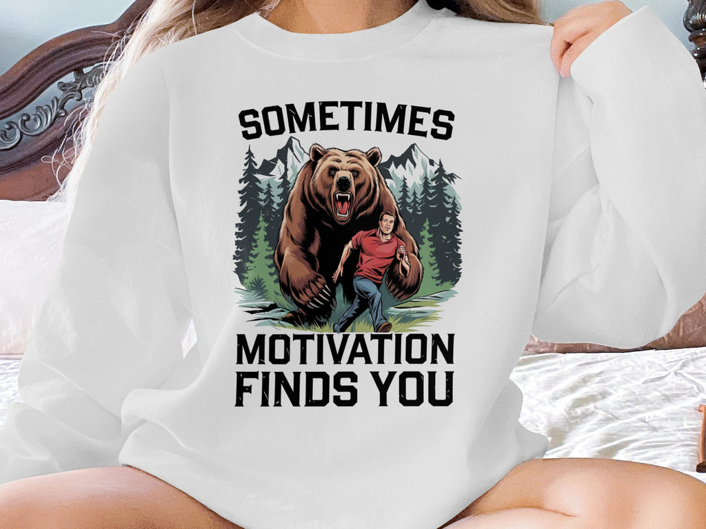 Bear chasing a man with text "Sometimes Motivation Finds You" on sweatshirt.