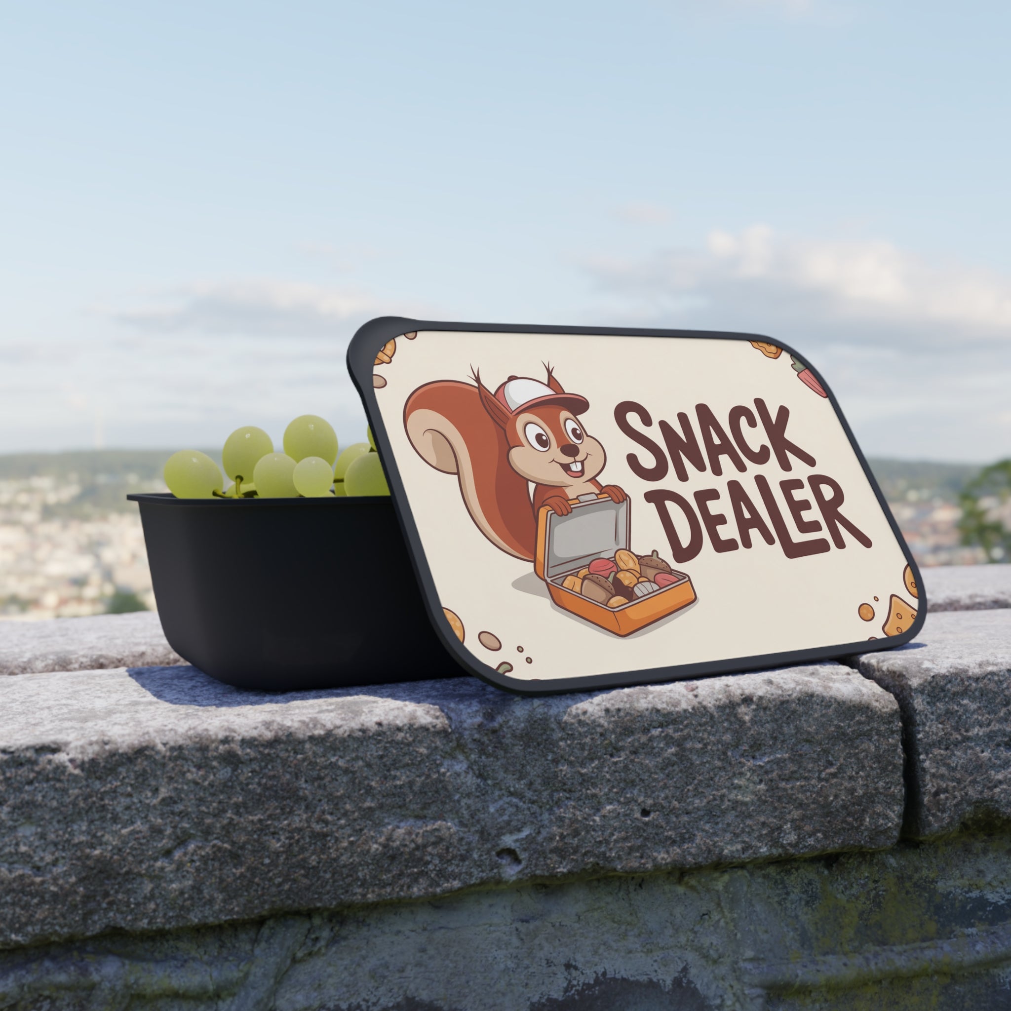 Bowl of grapes next to a sign with a squirrel and "Snack Dealer" text.