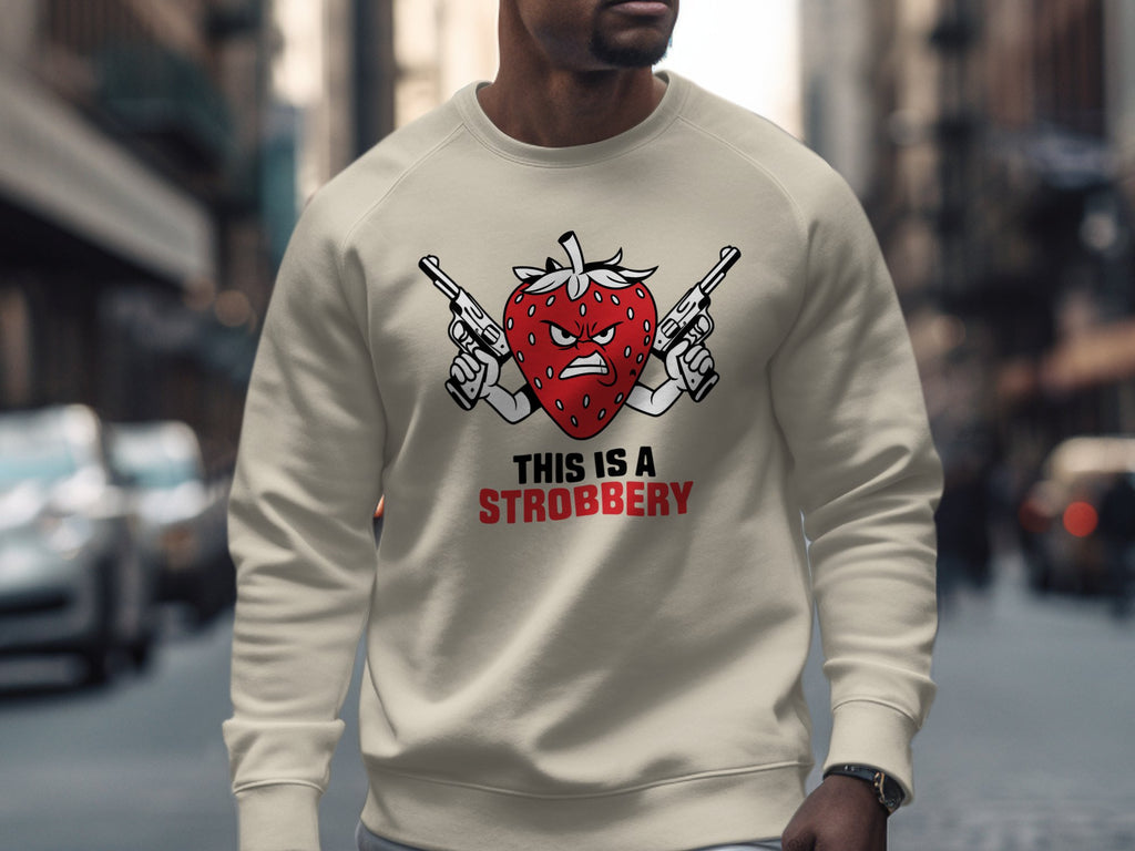 Cream sweatshirt with a cartoon strawberry holding two guns and text "THIS IS A STROBERRY".