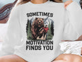 Bear chasing man in front of mountains, text: Sometimes Motivation Finds You.