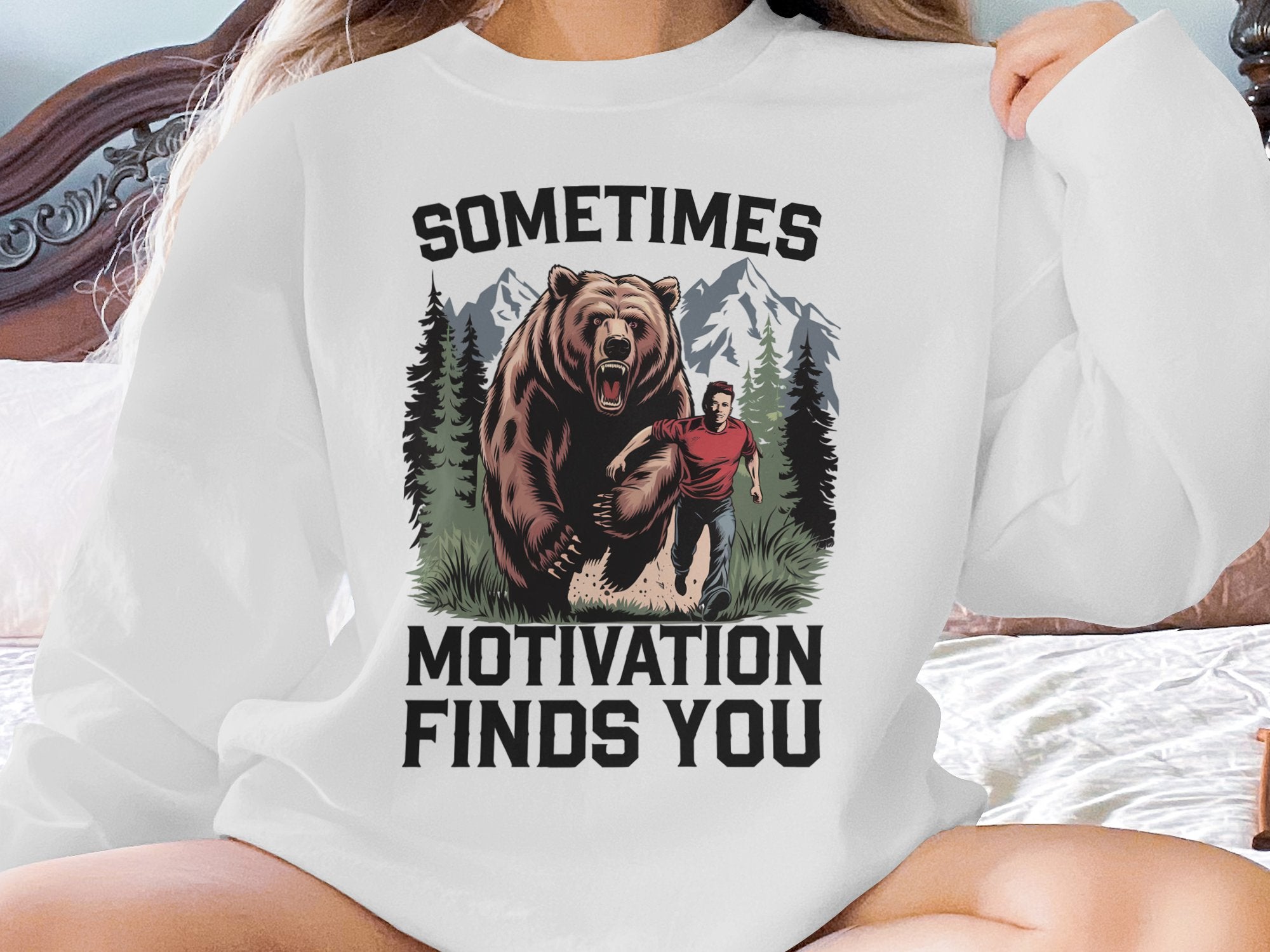 Bear chasing man in front of mountains, text: Sometimes Motivation Finds You.