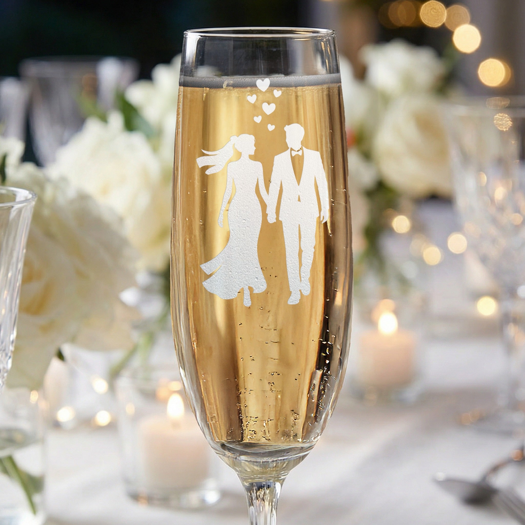 Champagne flute with etched silhouette of a bride and groom, wedding bubbles.