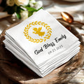 White napkin with golden angel, wreath, and text "God Bless Emily 09.25.2025".