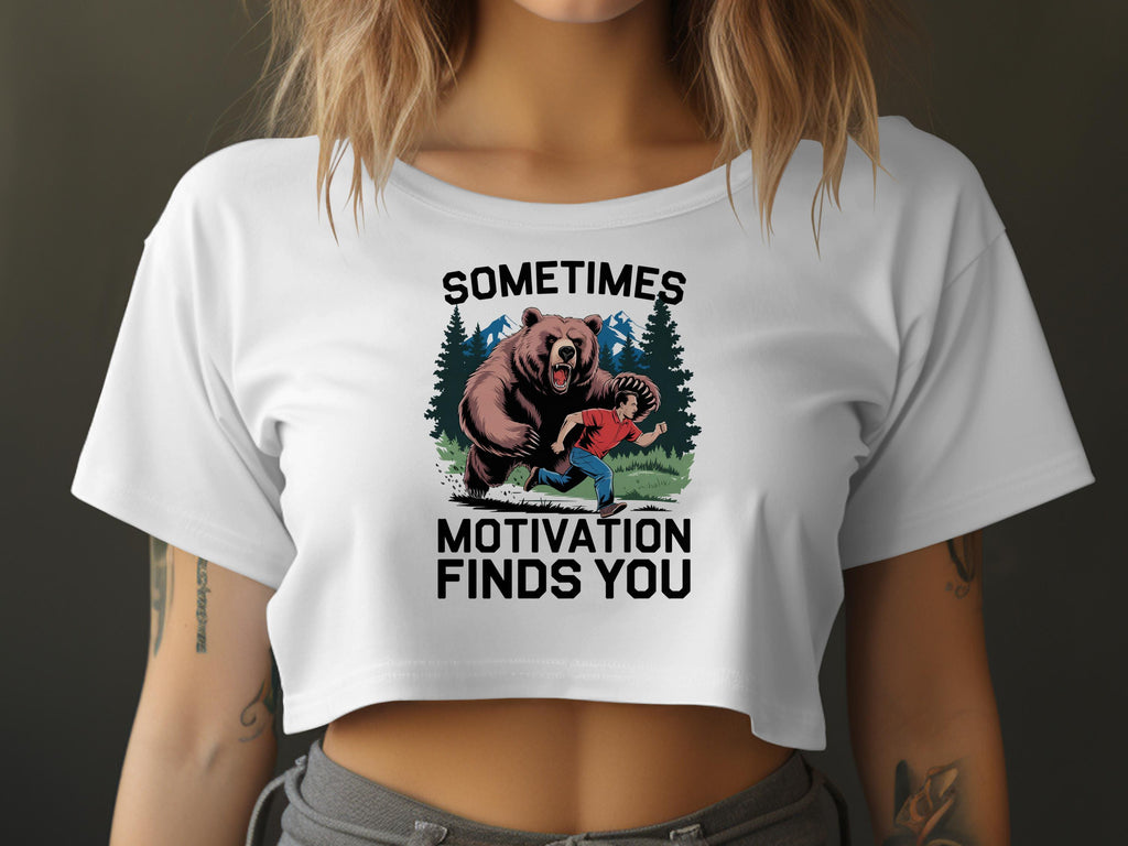 White t-shirt with "Sometimes motivation finds you" and illustration of a man running from a bear.