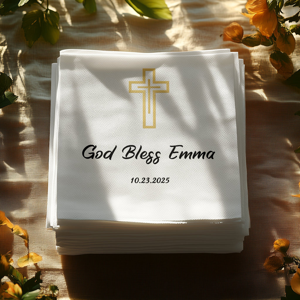 Stack of white napkins with a gold cross and "God Bless Emma" text.