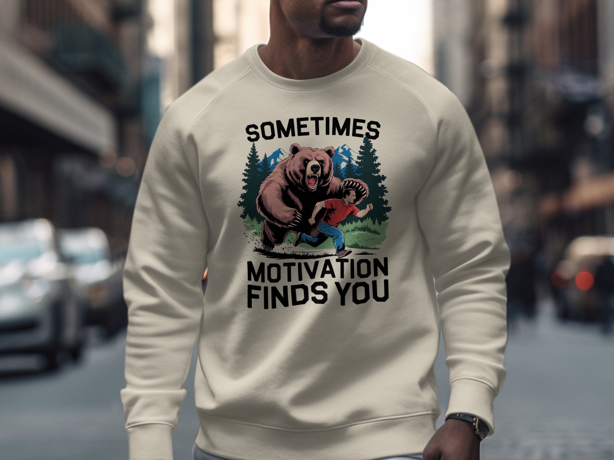 Crewneck sweatshirt with graphic of man running from bear and text "Sometimes Motivation Finds You".